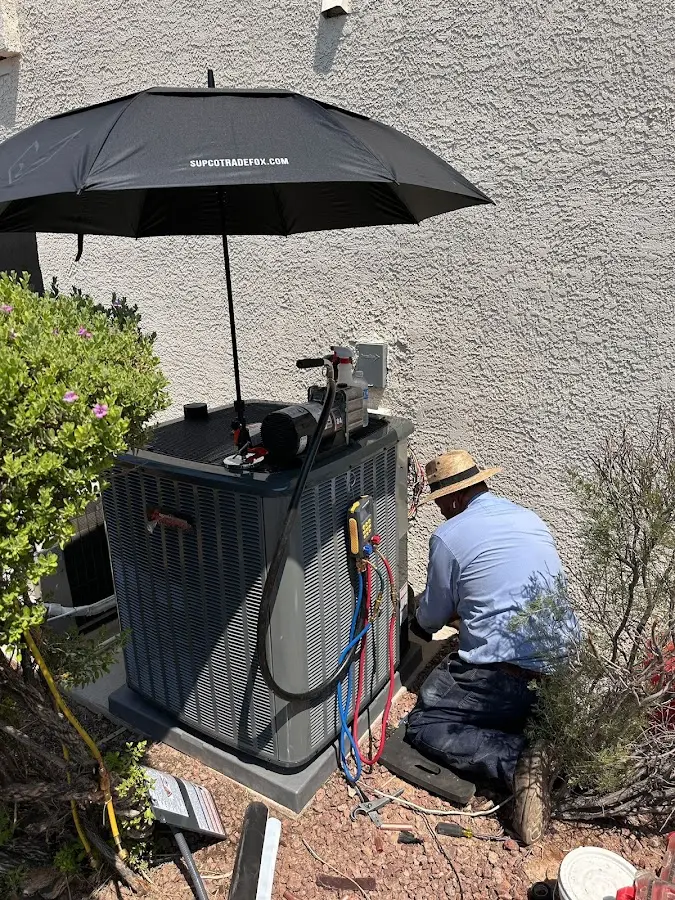 HVAC technician performing outdoor AC maintenance in Joshua Tree